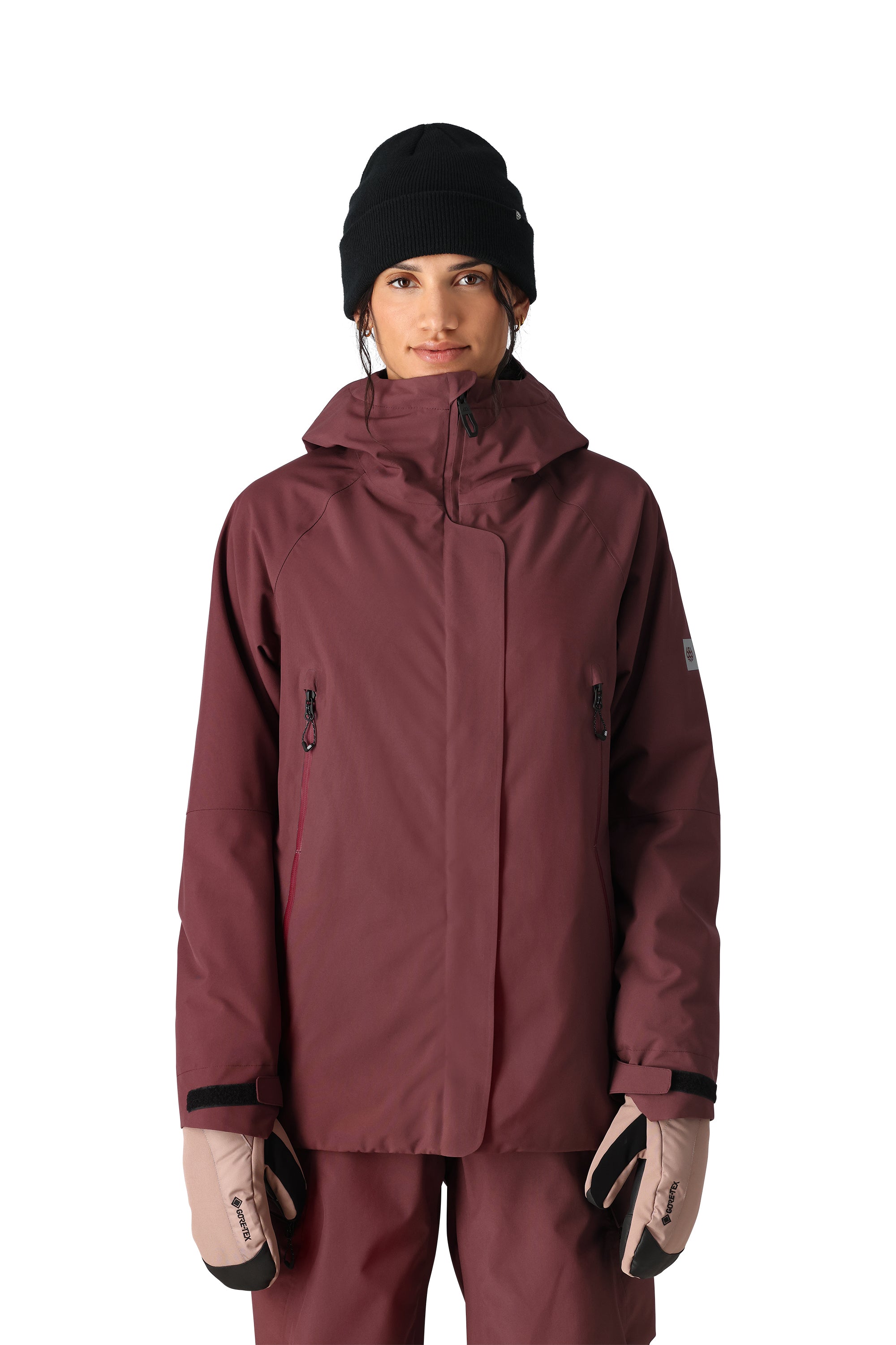 The 686 Whisper Insulated Jacket is primarily burgundy with black accents and a large collar.