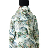 The 686 Whisper Insulated Jacket appears to be predominantly white with black accents and a leaf pattern in shades of green, blue, and pink.