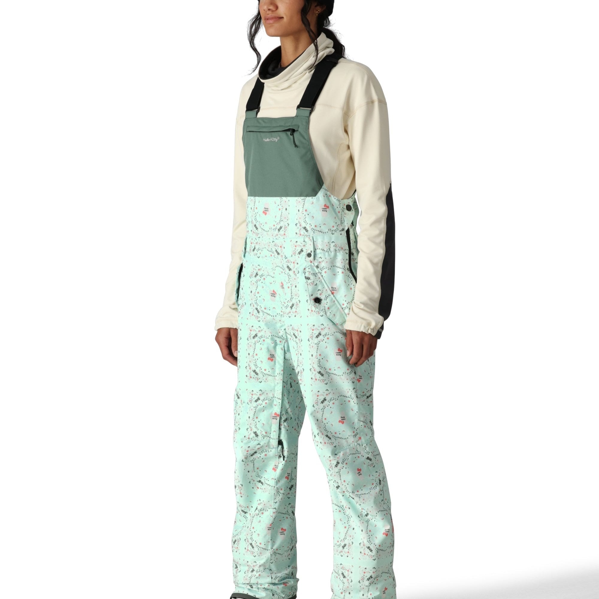 The 686 Women's Harper Shell Bib in light blue features a zip-in bib with an insulated hood, side zip pockets, and adjustable straps.