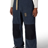 Men's 2.5L shell pant in navy with corduroy texture, black panels, logo