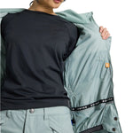 Burton Women's Lelah 2L Jacket 2025 - A light blue jacket with a hood, worn by a model who is facing away from the camera and looking down at her feet.