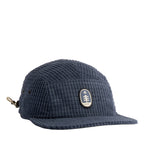 Blue textured 5-panel cap with a logo on a light gray background