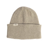 Beige knit beanie with 'COAL' label on a light gray background