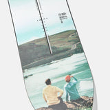 Burton Women's Family Tree Story Board B Grade Snowboard 2024 - A snowboard with a white base and black graphics of trees, mountains, and a sunset.