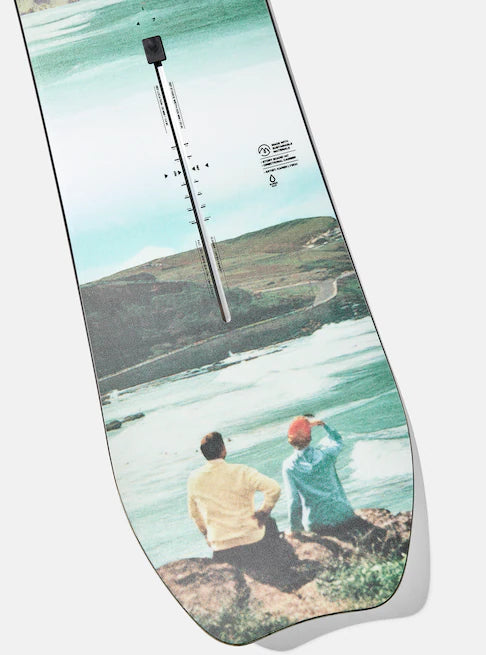 Burton Women's Family Tree Story Board B Grade Snowboard 2024 - A snowboard with a white base and black graphics of trees, mountains, and a sunset.