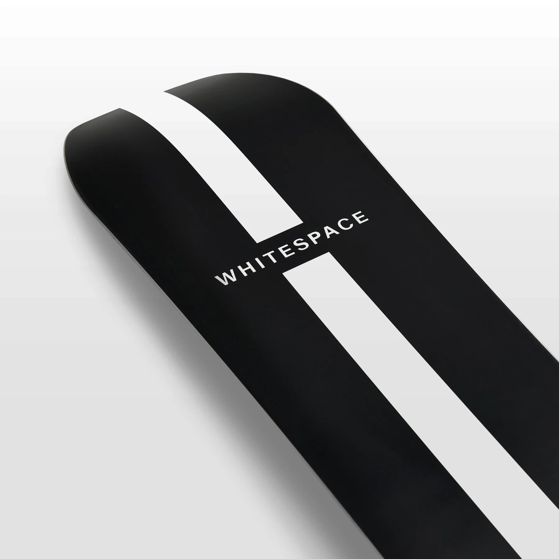 Whitespace Freestyle Shaun White Pro Limited Edition Snowboard 2024 - A black snowboard with a white stripe down the middle and a distinctive "S" logo on top, featuring a sleek design with a subtle sheen.