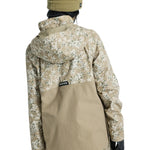 Burton Women's Frosnter Anorak Jacket 2025 - A tan jacket with a white and green snowflake pattern, featuring a hood and zippered pockets.