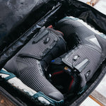 Burton Gig 70L Duffel Bag - A black duffel bag with a white logo on the side and a handle at the top.