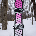 Burton Junior's Smalls Snowboard 2025 - A pink snowboard with black stripes and a black border, standing upright in the snow.