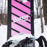 Burton Junior's Smalls Snowboard 2025 - A pink snowboard with black stripes and a black binding on top.