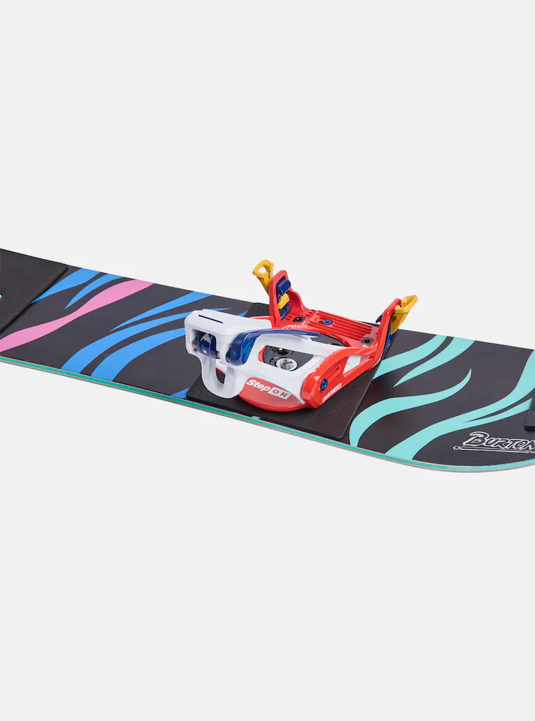 Burton Junior's Grom Step On Snowboard Bindings - A black snowboard with blue and pink stripes, featuring a red, white, and blue binding in the center.