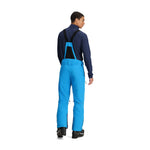 Obermeyer Force Insulated Suspender Pant 2025 - A pair of bright blue snow pants with black suspenders and a black zipper on the back pocket.