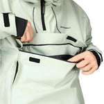 Beyond Medals Anorak 2L Shell Jacket 2024 - A light green jacket with black accents and a hood, featuring two zippered pockets on the front.