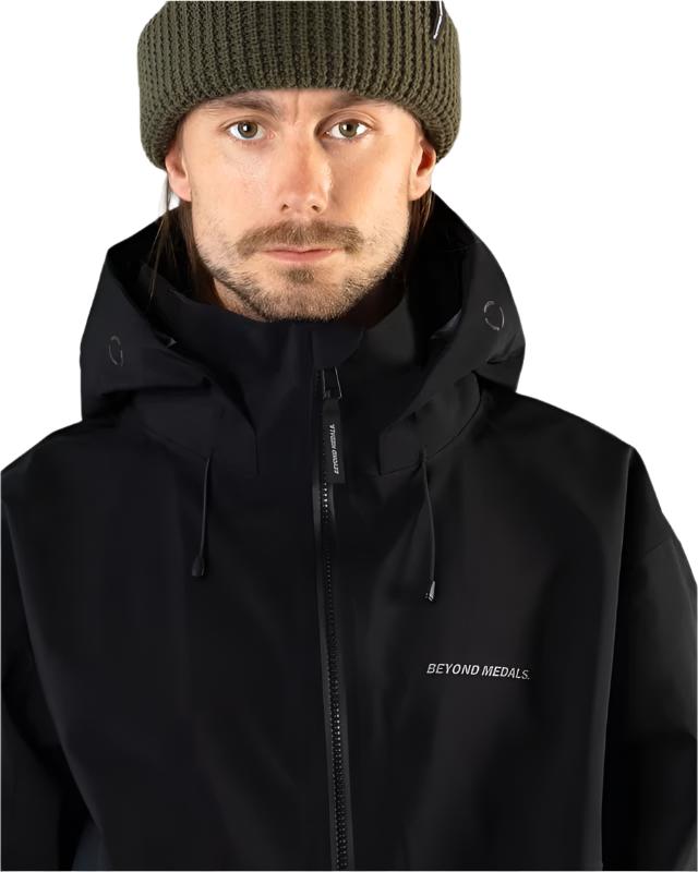 Beyond Medals Tech Shell Jacket 3L 2025 - A black jacket with a hood and zipper, featuring a small logo on the left chest area.