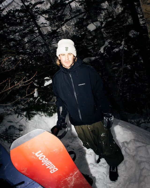 Beyond Medals Tech Shell Jacket 3L 2025 - A black jacket with a white logo on the chest and two zippered pockets on the front.