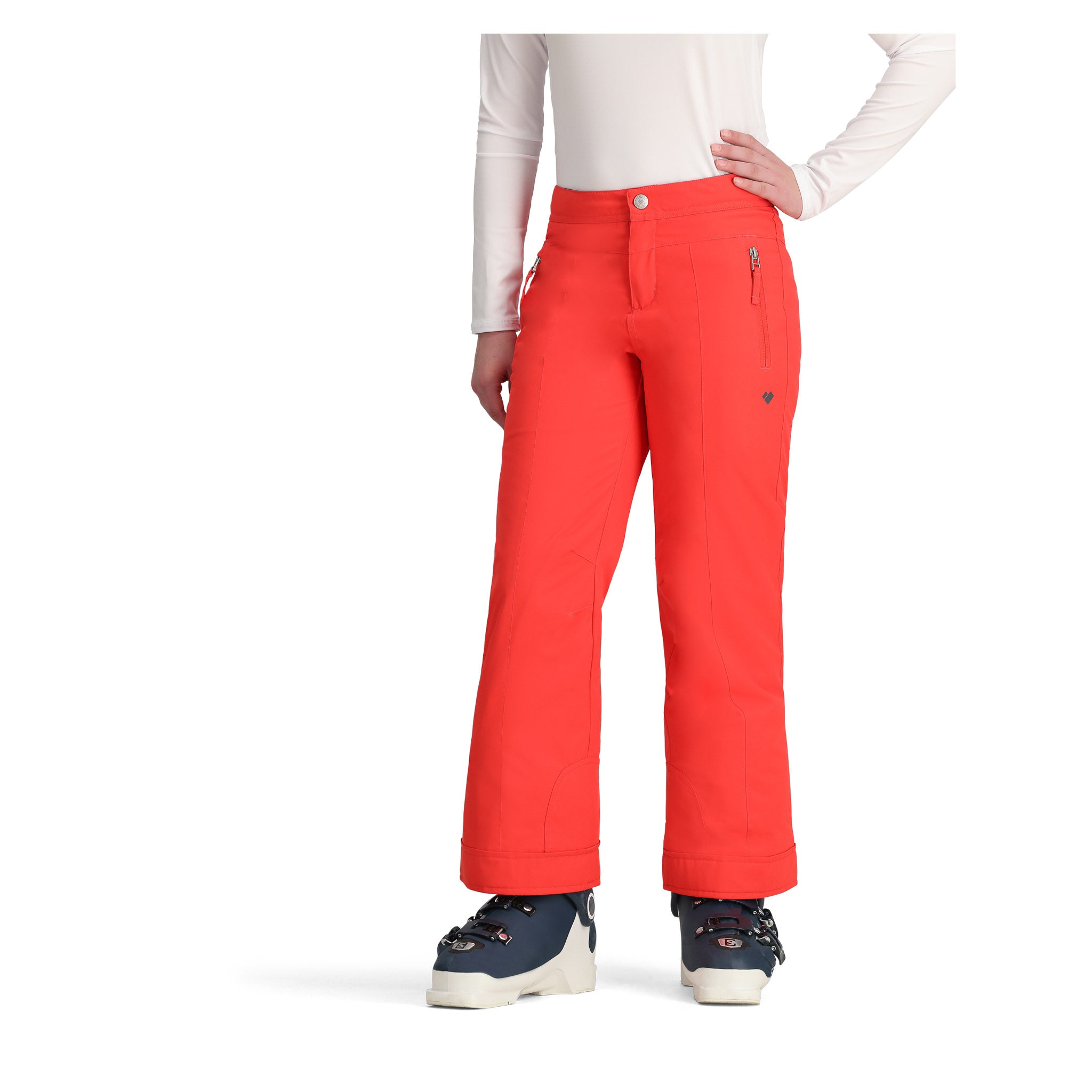 Obermeyer Girl's Brooke Insulated Pant 2025 - A pair of bright coral-colored snow pants with a small pocket on the right side and two zippered pockets on the left side.
