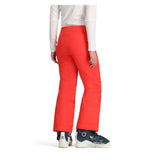 Obermeyer Girl's Brooke Insulated Pant 2025 - A pair of bright coral-colored snow pants with a subtle pattern and zippered pockets.