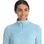 Spyder Women's Shimmer Bug 1/2 Zip Fleece 2025 - A light blue fleece jacket with a zipper and a small, sparkly bug logo on the chest.