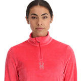 Spyder Women's Shimmer Bug 1/2 Zip Fleece 2025 - A woman wearing a pink fleece with a zipper down the front and a small logo on the chest.