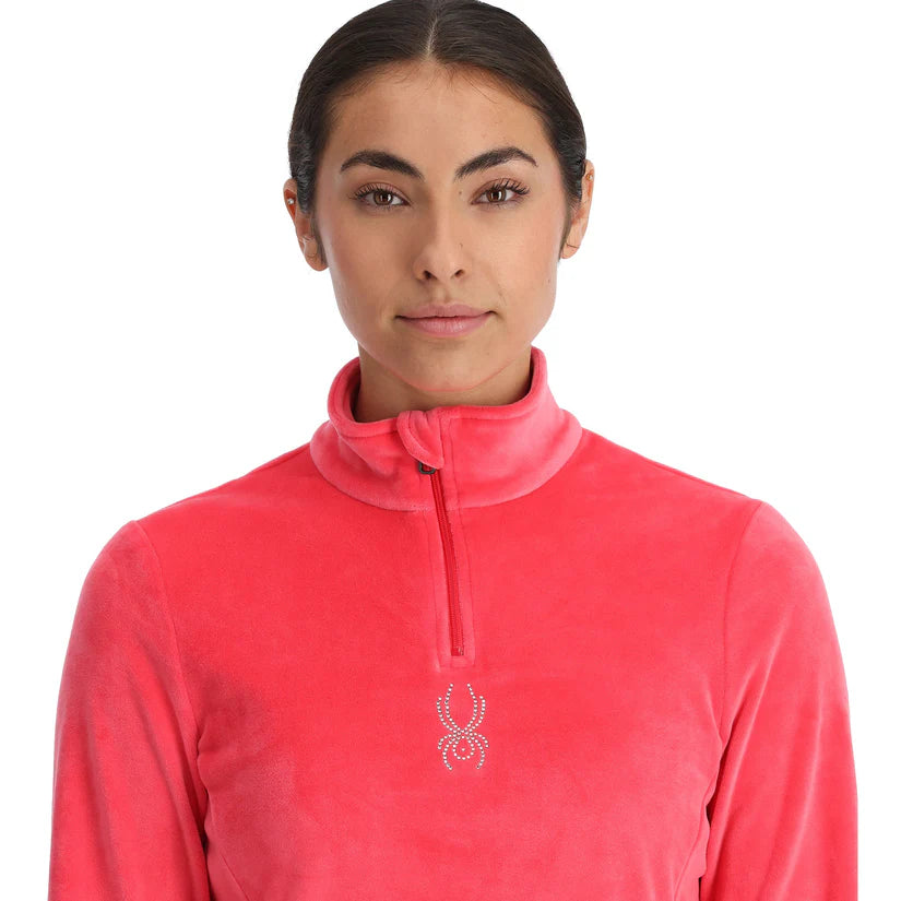 Spyder Women's Shimmer Bug 1/2 Zip Fleece 2025 - A woman wearing a pink fleece with a zipper down the front and a small logo on the chest.
