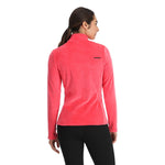 Spyder Women's Shimmer Bug 1/2 Zip Fleece 2025 - A woman wearing a pink fleece jacket with a zipper and black pants, facing away from the camera.