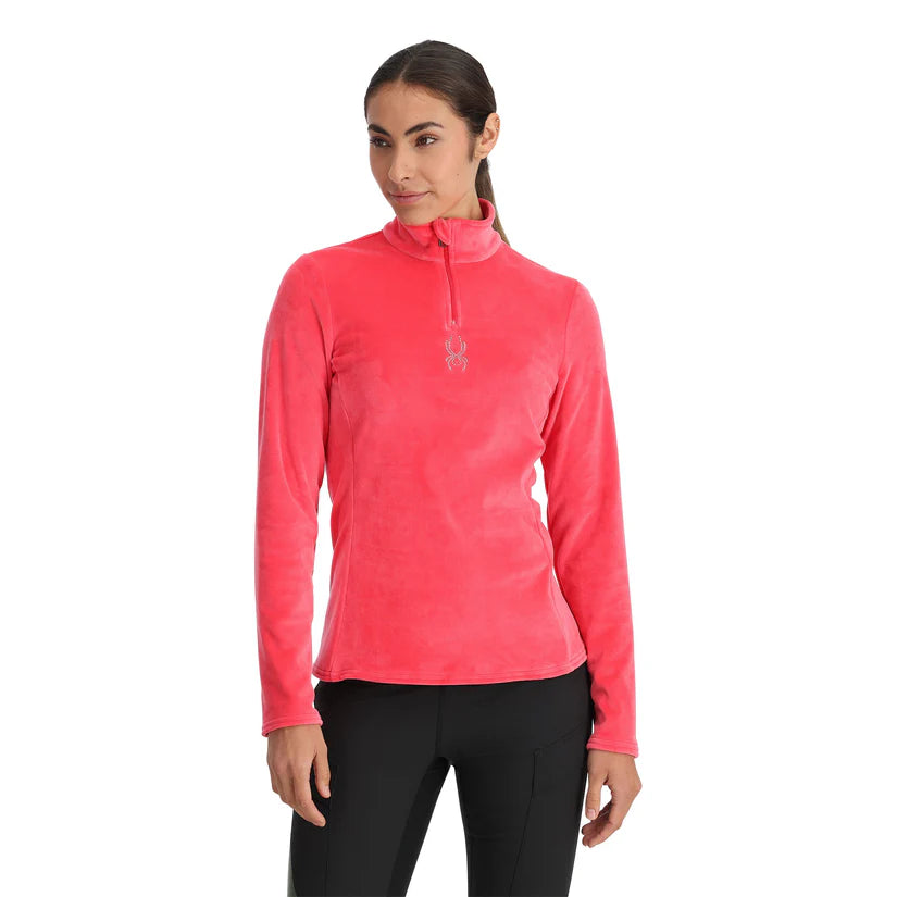 Spyder Women's Shimmer Bug 1/2 Zip Fleece 2025 - A woman wearing a pink fleece top with a zipper and a logo on the chest.