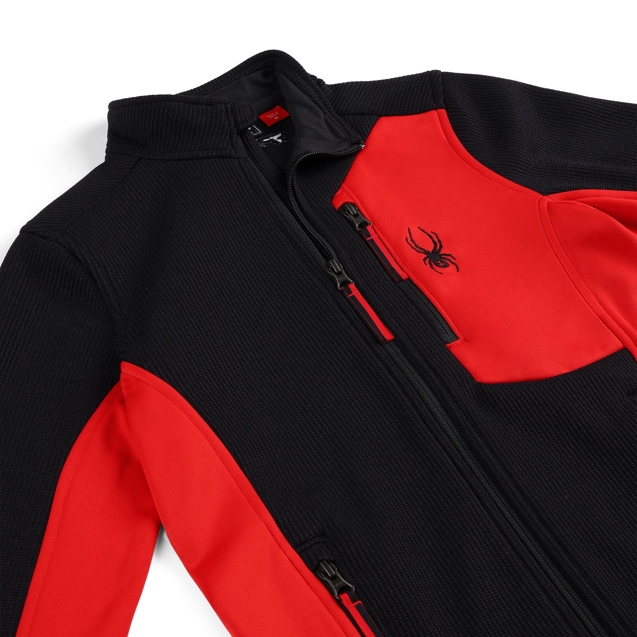 Spyder Youth Bandit Full-Zip Fleece Jacket 2025 - A black fleece jacket with a red zipper and a small embroidered spider logo on the chest.