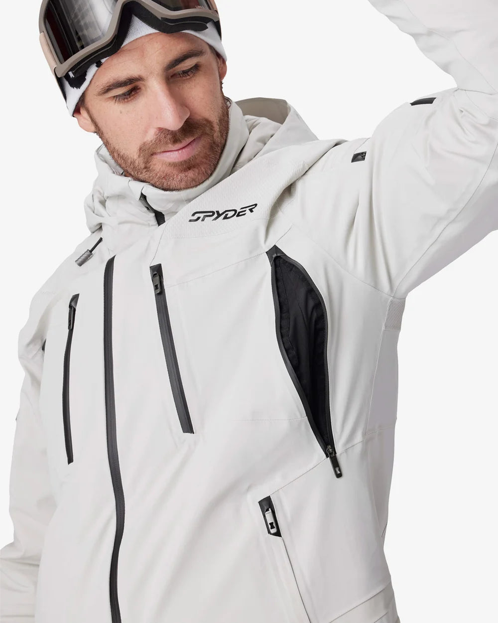 Light grey Spyder insulated jacket with hood, front zip, chest pockets, and side vent panel.
