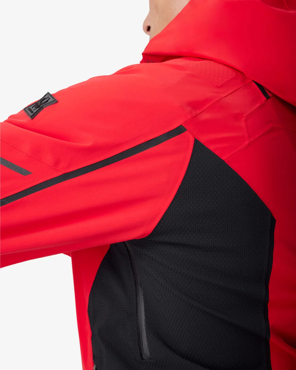 Red insulated jacket shoulder and sleeve with black accent panel and zipper seam