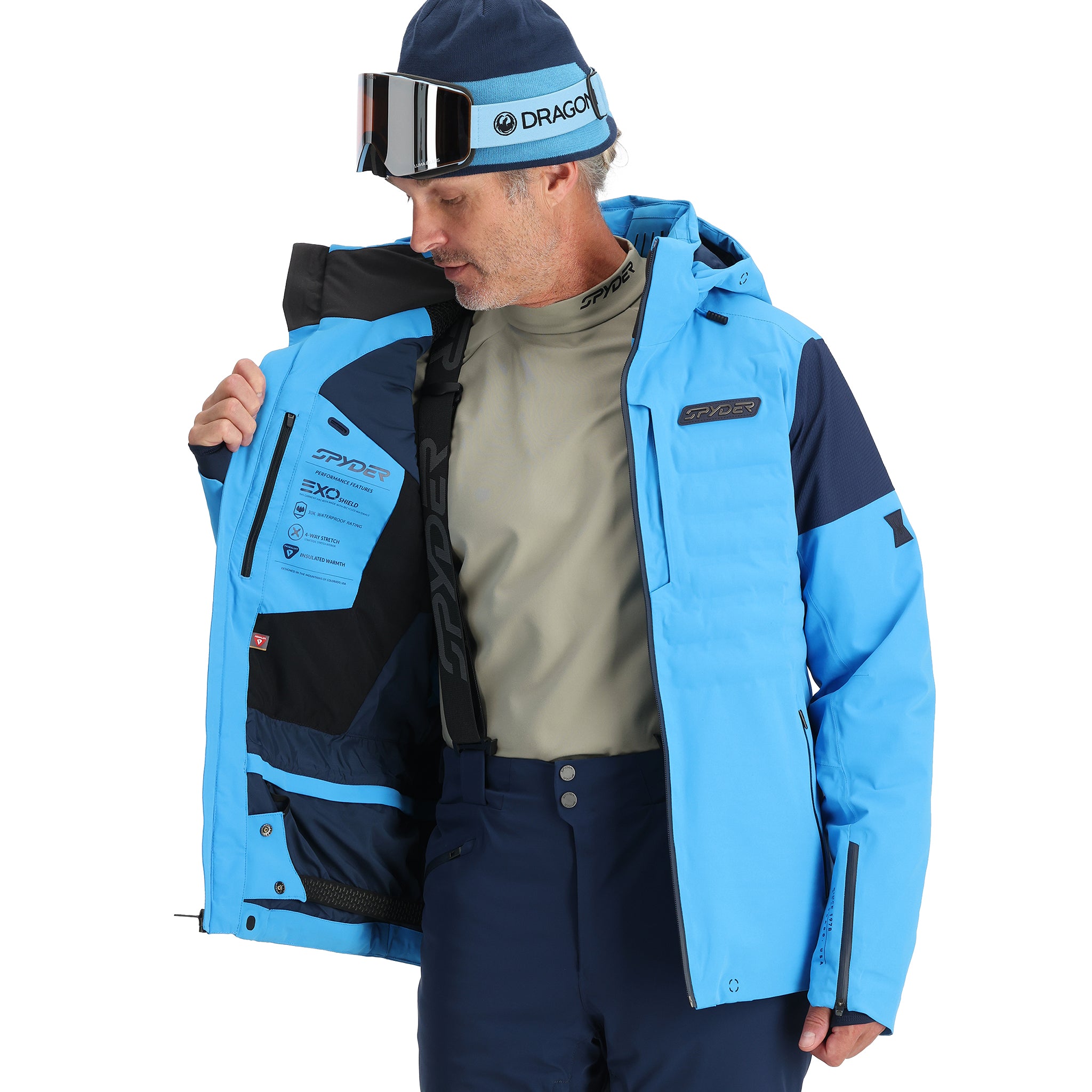 Spyder Pinnacle Insulated Jacket - A man wearing a light blue jacket with black accents and a high collar, holding it open to show the inside lining.