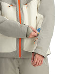 Spyder Copper Insulated Jacket - A woman's hand is adjusting a zipper on the jacket, which has a copper-colored zipper and a black pull tab.