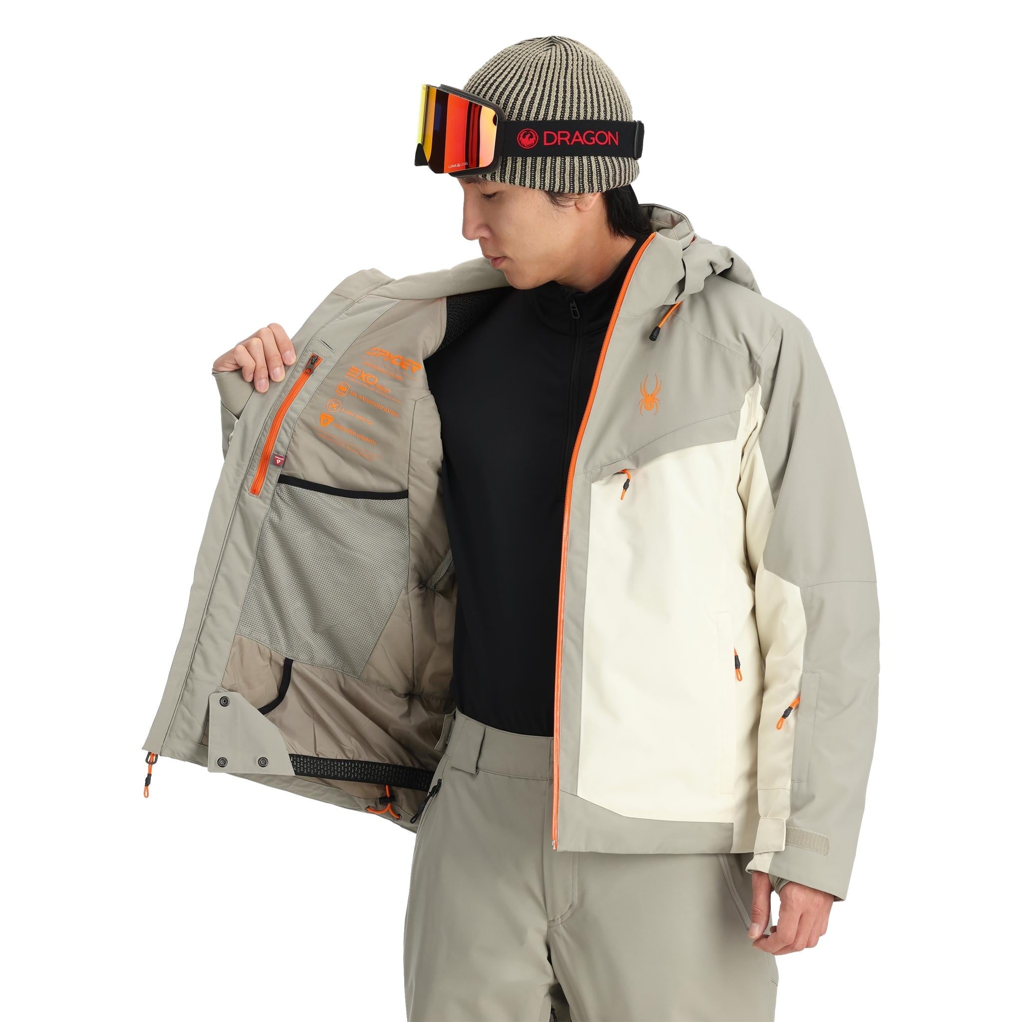 Spyder Copper Insulated Jacket - A tan jacket with copper-colored accents on the zipper and logo, featuring a hood and zippered pockets.