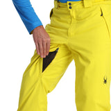 Spyder Men's Boundary Insulated Pants - A pair of bright yellow ski pants with a black zipper on the left thigh and two black buttons on the waistband.