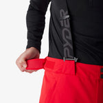 Insulated ski pants front with red belt, black waistband, and button detail