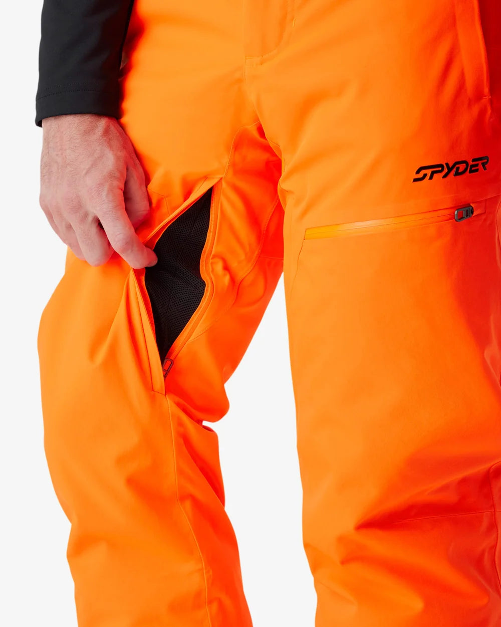 Insulated ski pants close-up with orange fabric, side pocket opening, and zipper detail