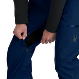 Spyder Men's Dare Insulated Pant - A pair of navy blue ski pants with a zippered fly and two front pockets, featuring a black zipper pull on the right pocket.