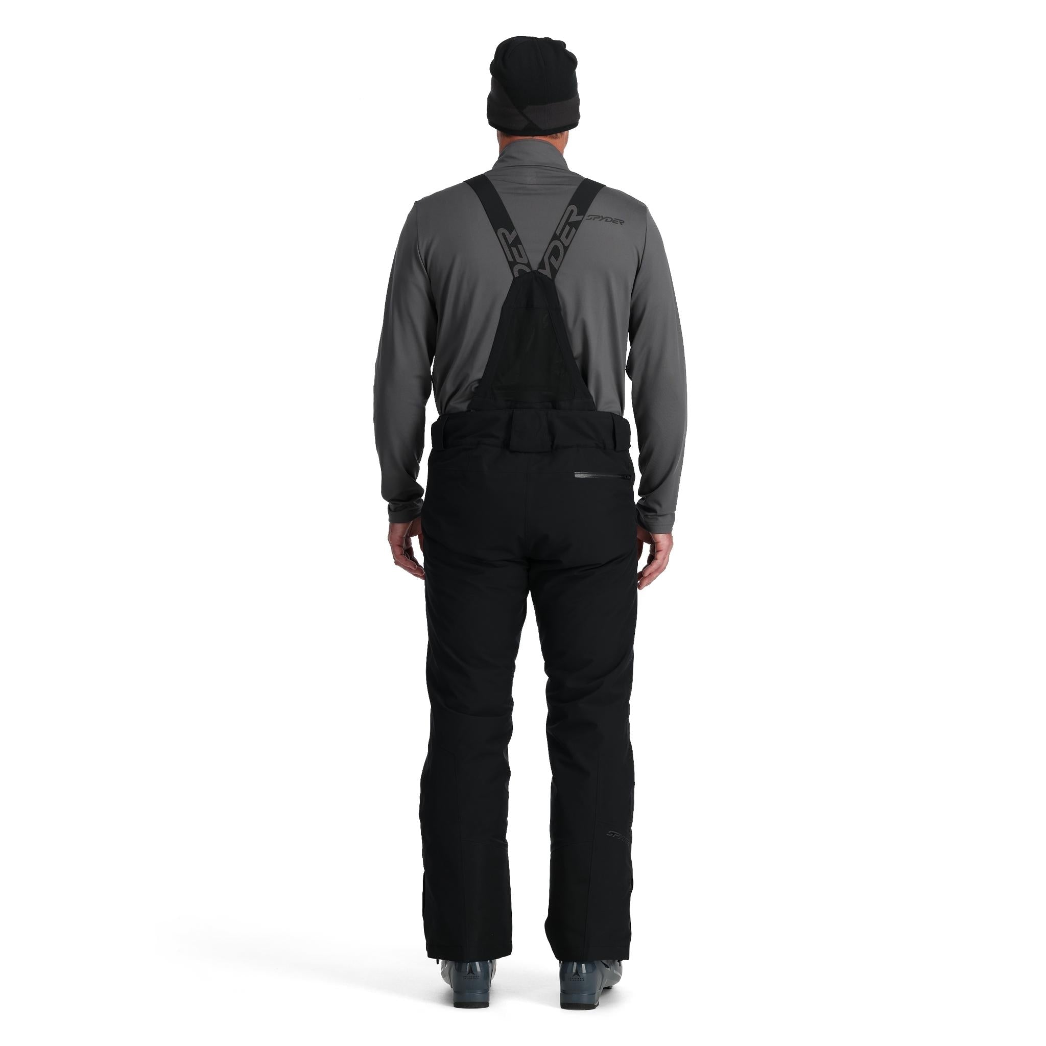 Spyder Men's Dare Insulated Pant Tall 2025 - Black snow pants with a subtle pattern of thin white lines on the left leg, worn by a model from behind.