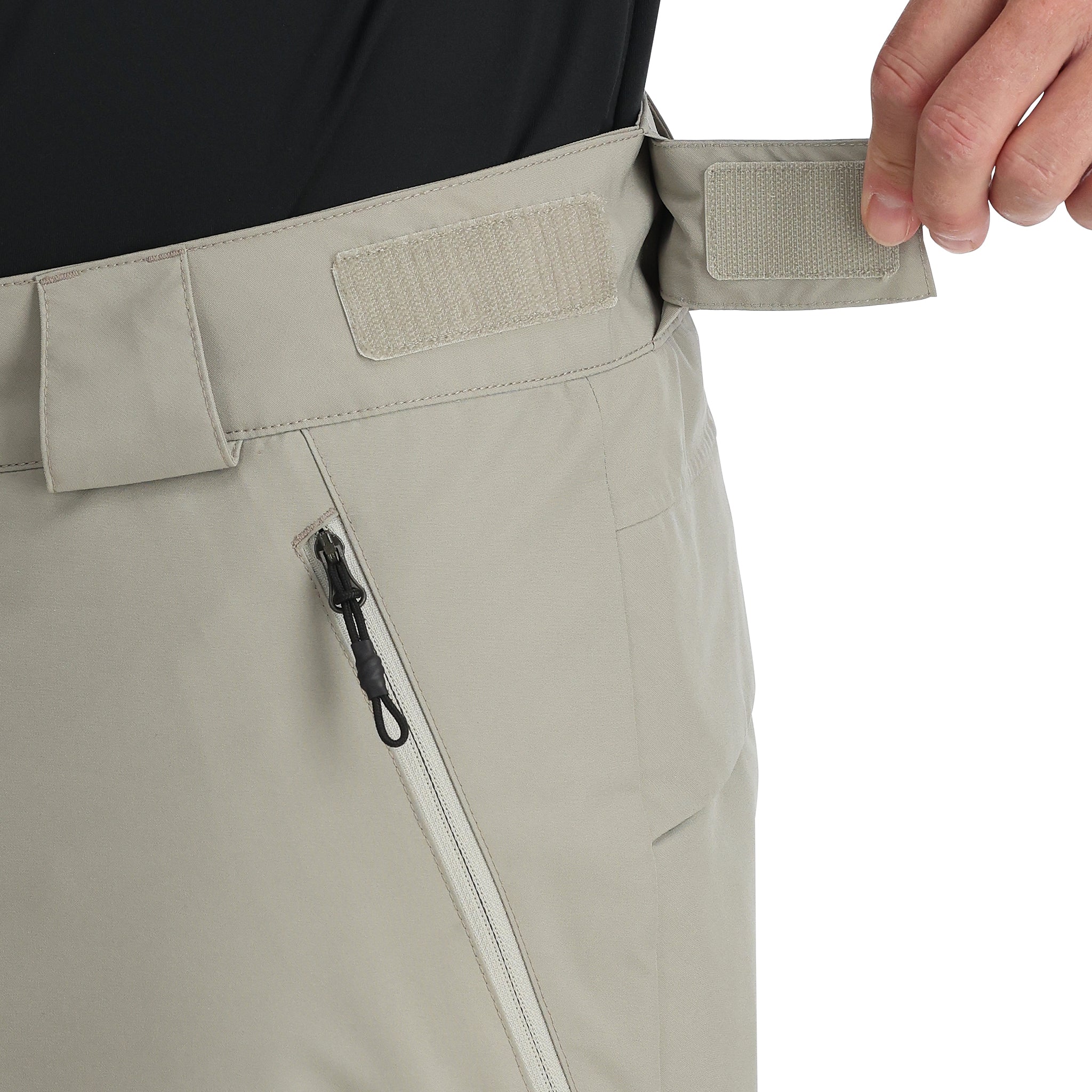 Spyder Men's Sentinel Insulated Pants - A pair of khaki-colored pants with a zippered fly and two front pockets, featuring a black zipper pull on one pocket.