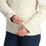 Spyder Women's Brisk Synthetic Down Jacket - A cream-colored jacket with a zippered front and two chest pockets, featuring a subtle pattern of diagonal stripes on the upper back.