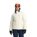 Spyder Women's Brisk Synthetic Down Jacket - A white down jacket with a high collar and zippered pockets, featuring a hood and a black zipper.
