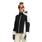 Spyder Women's Andorra Insulated Jacket 2025 - A black and white ski jacket with a zippered chest pocket, worn by a model on a plain background.