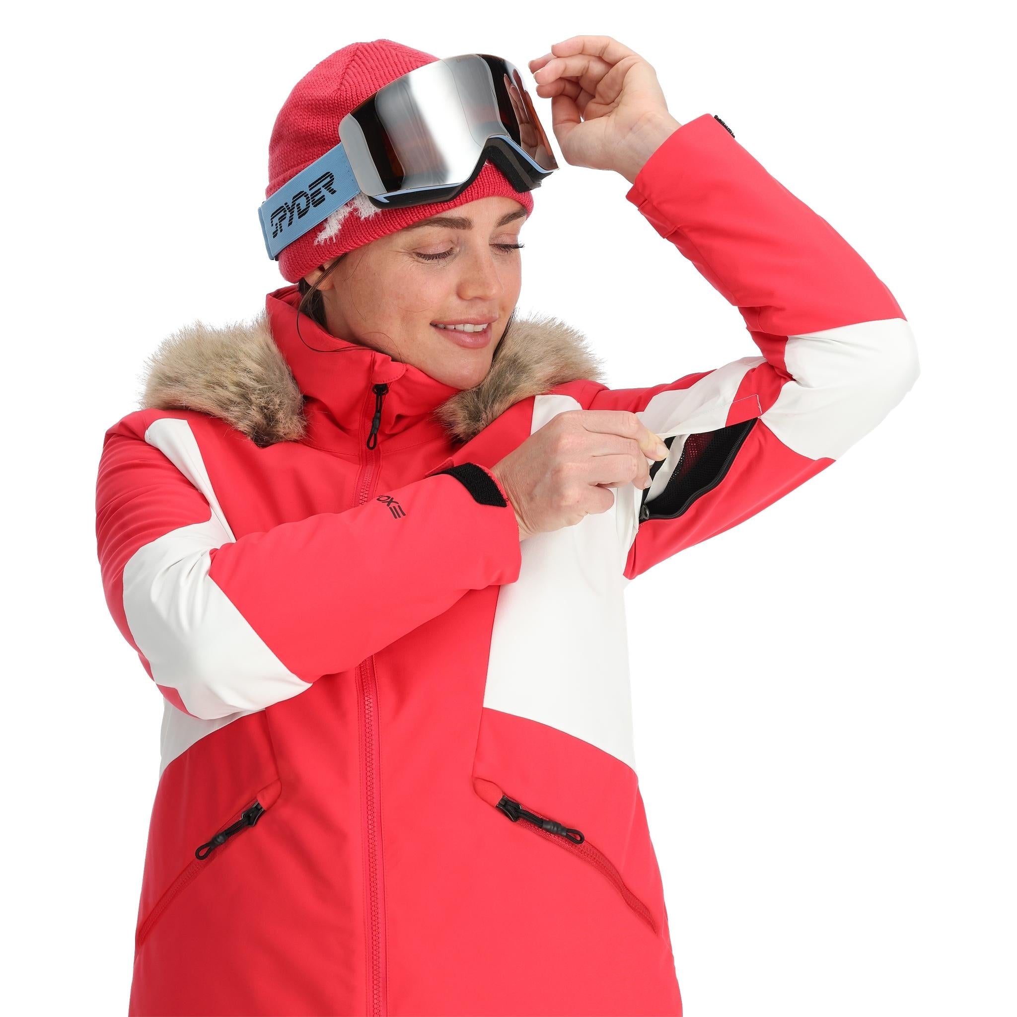 Spyder Women's Vida Insulated Faux Fur Jacket - A pink and white jacket with a faux fur-lined hood, featuring a zipper closure and two zippered pockets on the front.