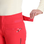 Spyder Women's Winner Insulated Pants 2025 - A pair of red ski pants with a zippered pocket on the right thigh and a black logo on the left leg.