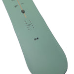 Arbor Formula Decon 2026 - A light green snowboard with a brown stripe down the middle and small black dots on either side of it.