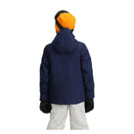 Obermeyer Junior's Insulated Gentleman's Jacket - A navy blue jacket with a hood, worn by a model from behind.