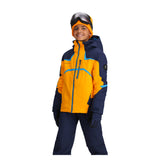 Obermeyer Juniors Mach 15 Insulated Jacket - A bright orange jacket with a navy blue hood and accents, featuring a zippered chest pocket and two side pockets.
