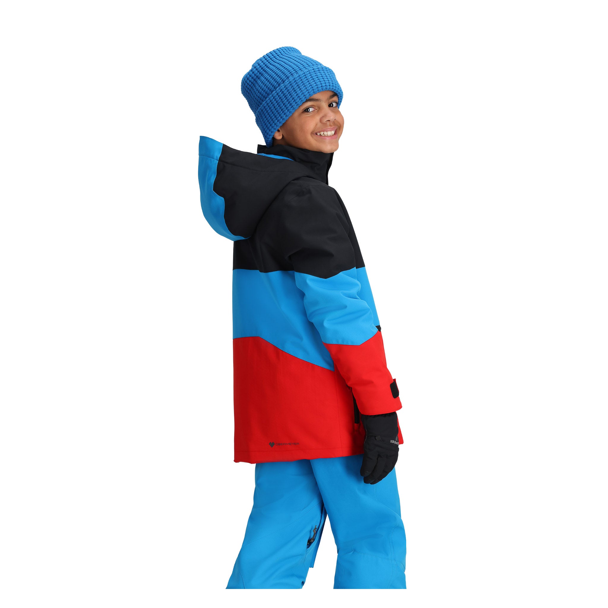 Obermeyer Junior's Axel Insulated Jacket 2025 - A black, red, and blue jacket with a hood on a young boy wearing it.