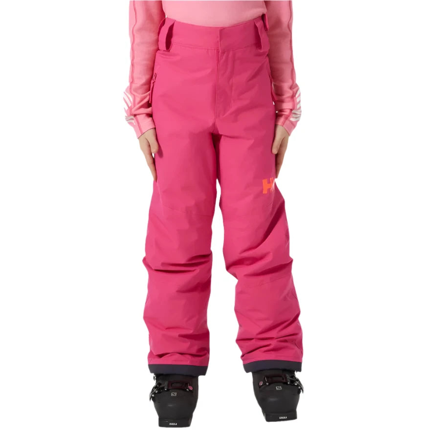 Helly Hansen Junior's Legendary Insulated Pant 2025 - A pair of bright pink insulated ski pants with a white logo on the left thigh and two zippered pockets on the right side.