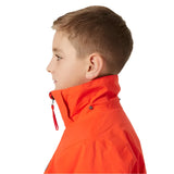 Helly Hansen Junior's Traverse Insulated Jacket - A bright orange jacket with a black zipper and two black buttons on the left side of the chest.