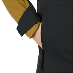 Helly Hansen Junior's Traverse Insulated Jacket 2025 - A black insulated jacket with a yellow zipper and trim on the front, worn by a model against a white background.